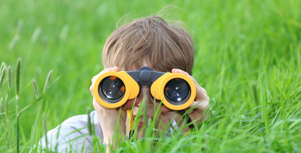A child looking though a pair of binoculars.